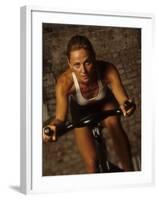 Young Woman Exercising on a Stationary Bike-null-Framed Photographic Print