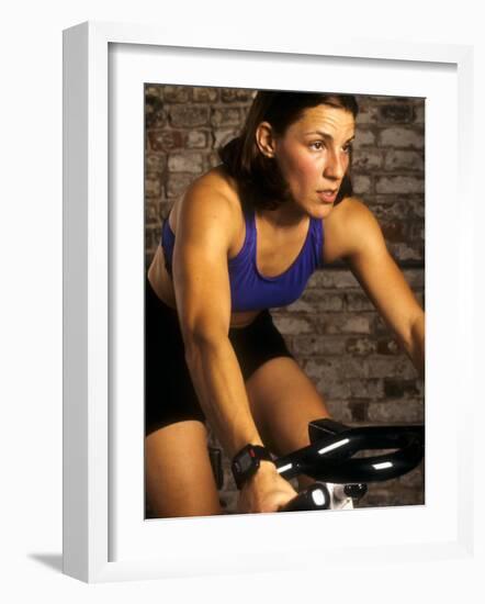 Young Woman Exercising on a Stationary Bike-null-Framed Photographic Print