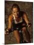 Young Woman Exercising on a Stationary Bike-null-Mounted Photographic Print