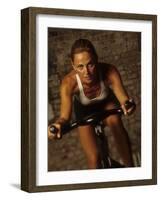 Young Woman Exercising on a Stationary Bike-null-Framed Photographic Print