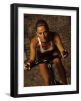 Young Woman Exercising on a Stationary Bike-null-Framed Photographic Print