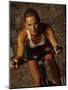 Young Woman Exercising on a Stationary Bike-null-Mounted Photographic Print