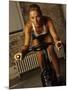 Young Woman Exercising on a Stationary Bike-null-Mounted Photographic Print