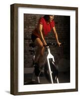 Young Woman Exercising on a Stationary Bike-null-Framed Photographic Print