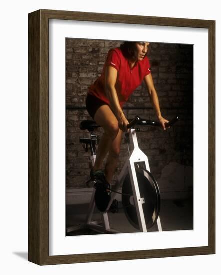 Young Woman Exercising on a Stationary Bike-null-Framed Photographic Print