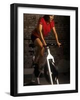 Young Woman Exercising on a Stationary Bike-null-Framed Photographic Print