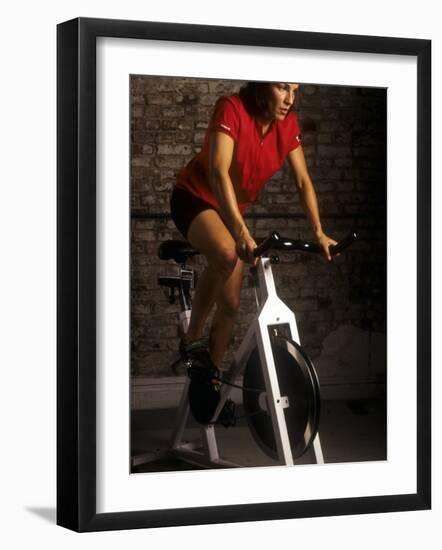 Young Woman Exercising on a Stationary Bike-null-Framed Photographic Print