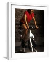 Young Woman Exercising on a Stationary Bike-null-Framed Photographic Print