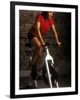 Young Woman Exercising on a Stationary Bike-null-Framed Photographic Print