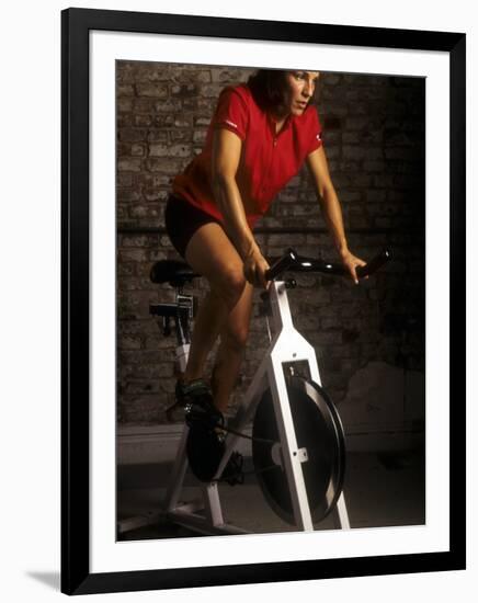 Young Woman Exercising on a Stationary Bike-null-Framed Photographic Print