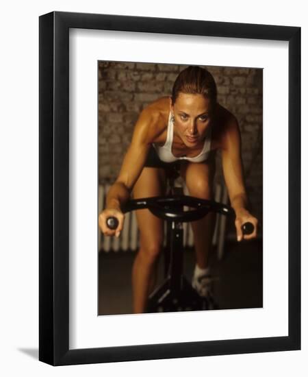 Young Woman Exercising on a Stationary Bike-null-Framed Photographic Print