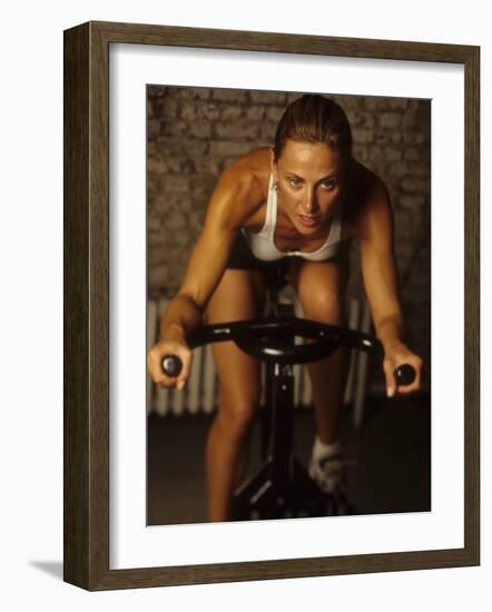 Young Woman Exercising on a Stationary Bike-null-Framed Photographic Print