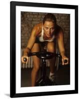 Young Woman Exercising on a Stationary Bike-null-Framed Photographic Print