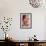 Young Woman Holding a Small Pink Flower-Carolina Hernandez-Framed Photographic Print displayed on a wall