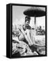 Young Woman in a Bikini Prepares to Go Snorkelling by Putting on Her Rubber Flippers-null-Framed Stretched Canvas