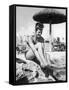 Young Woman in a Bikini Prepares to Go Snorkelling by Putting on Her Rubber Flippers-null-Framed Stretched Canvas