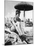 Young Woman in a Bikini Prepares to Go Snorkelling by Putting on Her Rubber Flippers-null-Mounted Photographic Print