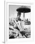 Young Woman in a Bikini Prepares to Go Snorkelling by Putting on Her Rubber Flippers-null-Framed Photographic Print