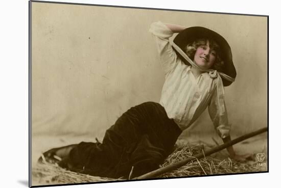 Young Woman in a Large Hat Sitting on Straw-null-Mounted Photographic Print