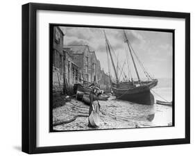 Young Woman in Headscarf and Working Clothes Looks out to Sea from the Shoreline-null-Framed Photographic Print