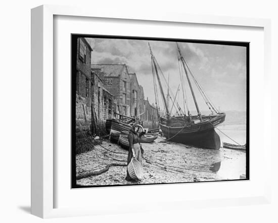 Young Woman in Headscarf and Working Clothes Looks out to Sea from the Shoreline-null-Framed Photographic Print