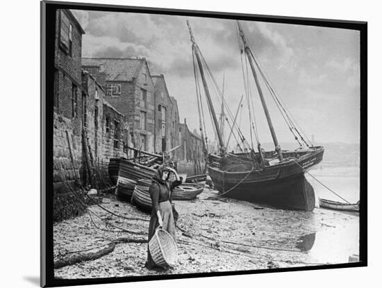 Young Woman in Headscarf and Working Clothes Looks out to Sea from the Shoreline-null-Mounted Photographic Print