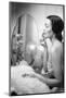 Young Woman Looking into a Mirror and Putting on Make Up-null-Mounted Photo