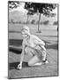 Young Woman on a Golf Course Placing a Golf Ball-null-Mounted Photo