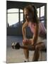 Young Woman Sitting on a Bench Lifting a Dumbbell-null-Mounted Photographic Print
