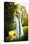 Young Woman Wearing a Long White Dress Holding a Sunflower Outdoor Shot. Portrait of Beautiful Girl-iancucristi-Stretched Canvas