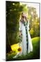 Young Woman Wearing a Long White Dress Holding a Sunflower Outdoor Shot. Portrait of Beautiful Girl-iancucristi-Mounted Photographic Print