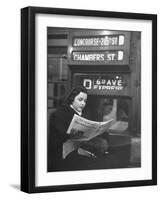 Young Woman Wearing a Winter Coat and Hat, Reading Beneath "D 6th Avenue" Sign, Riding the Subway-Eliot Elisofon-Framed Photographic Print