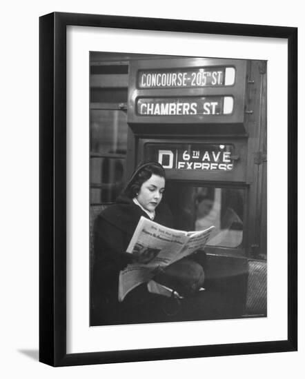 Young Woman Wearing a Winter Coat and Hat, Reading Beneath "D 6th Avenue" Sign, Riding the Subway-Eliot Elisofon-Framed Photographic Print