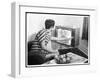 Young Woman with Short Dark Hair Wearing a Stripy Mini Dress Adjusts Her Television Set-null-Framed Art Print