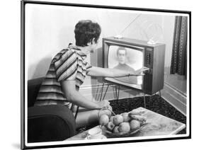 Young Woman with Short Dark Hair Wearing a Stripy Mini Dress Adjusts Her Television Set-null-Mounted Art Print