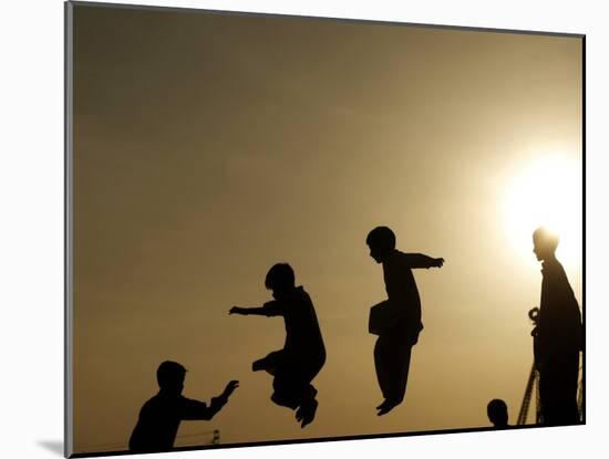 Youths Play on a Trampoline at Sunset in the Neighborhood of Islamabad, Pakistan-null-Mounted Photographic Print