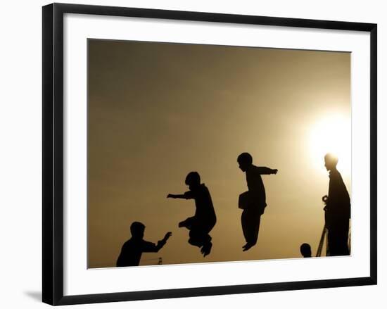 Youths Play on a Trampoline at Sunset in the Neighborhood of Islamabad, Pakistan-null-Framed Photographic Print