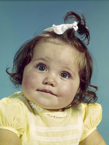 1960s Brunette Baby Girl Round Chubby Face Yellow Dress Ribbon Topknot Interested