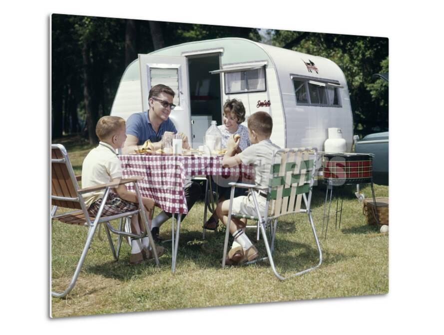 1960s Family Sitting In Lawn Chairs At Picnic Table Beside Camping