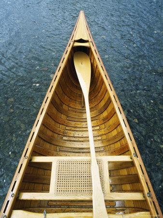 The Bow and Oar of a Handmade Wooden Canoe Resting in 