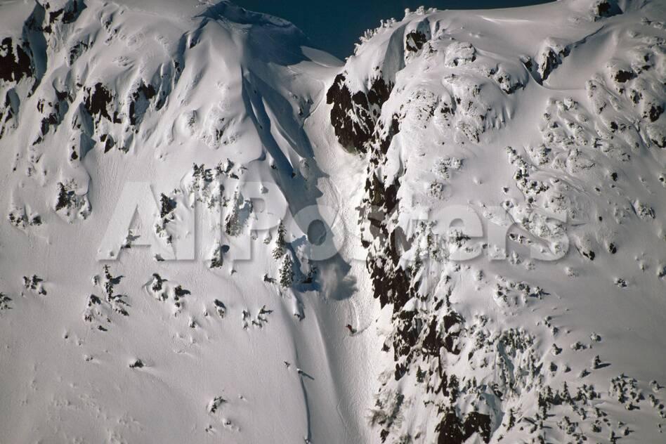 person snowboarding down chute