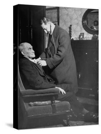 doctor making a house call to an ill elderly man