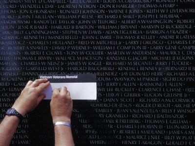 Man Making a Rubbing of a Name on the Vietnam Veterans 