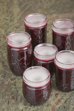 'Jars of blackberry jam with household wax (paraffin) on top to act as