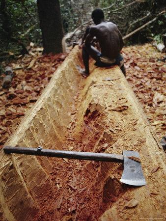 a man carving a dugout canoe from a log photographic print