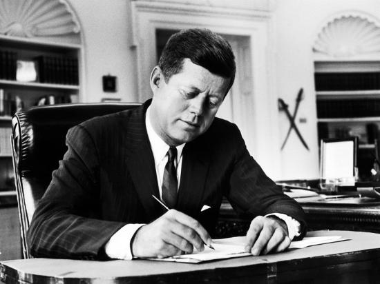 President John F Kennedy Working At His Desk In The Oval Office
