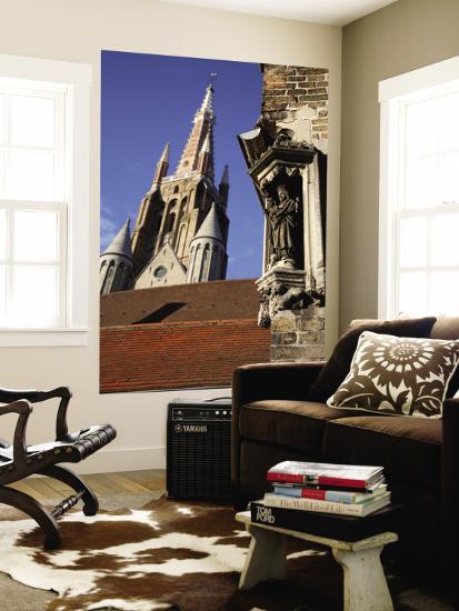 Saint Statue Decorating Corner Of House With Tower Of Church Of