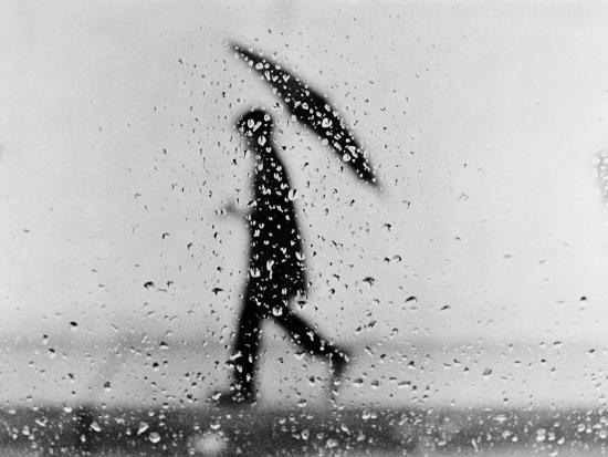 Silhouette Of Man Carrying An Umbrella Walking In The Rain